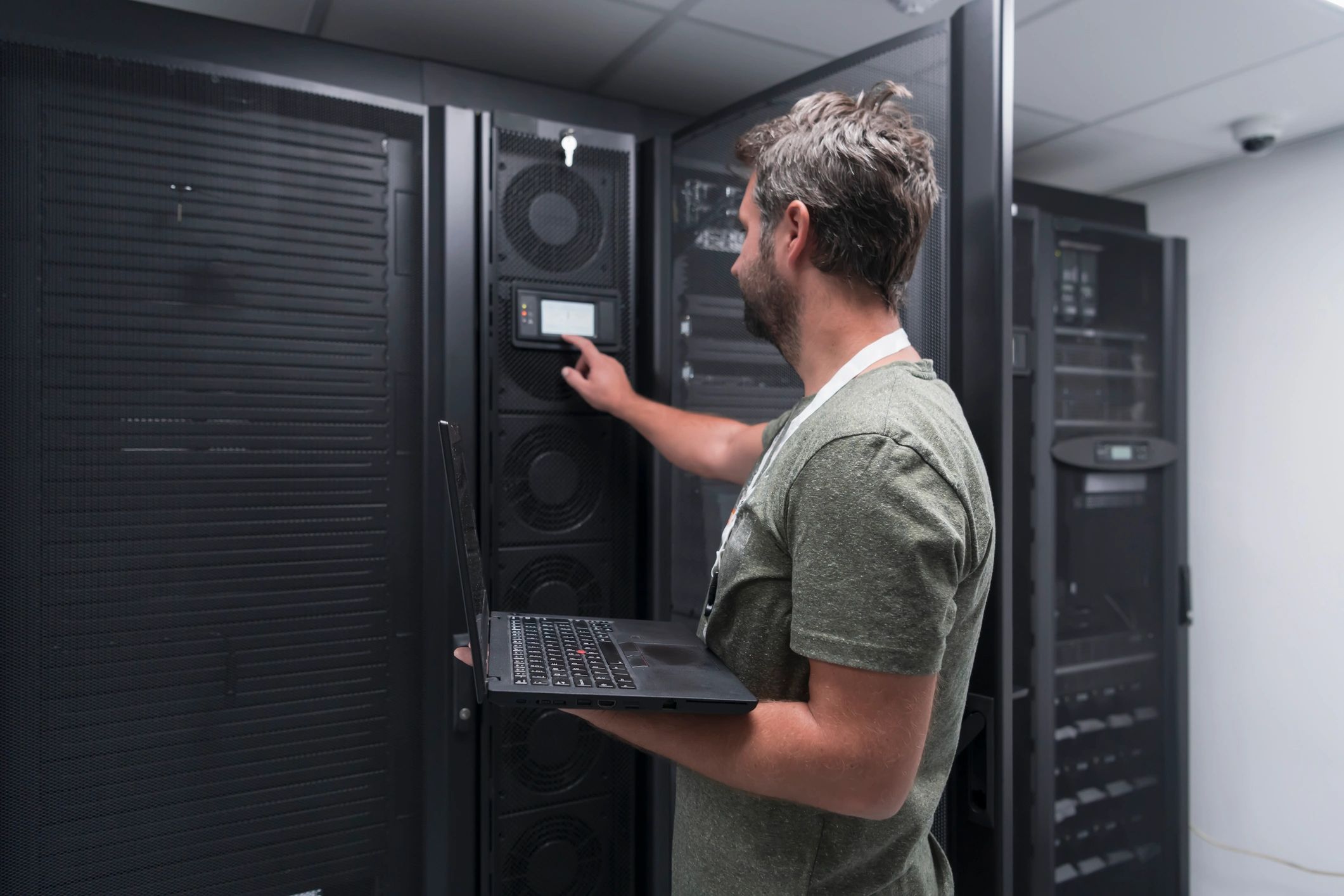 Engineer working on a laptop in a server room