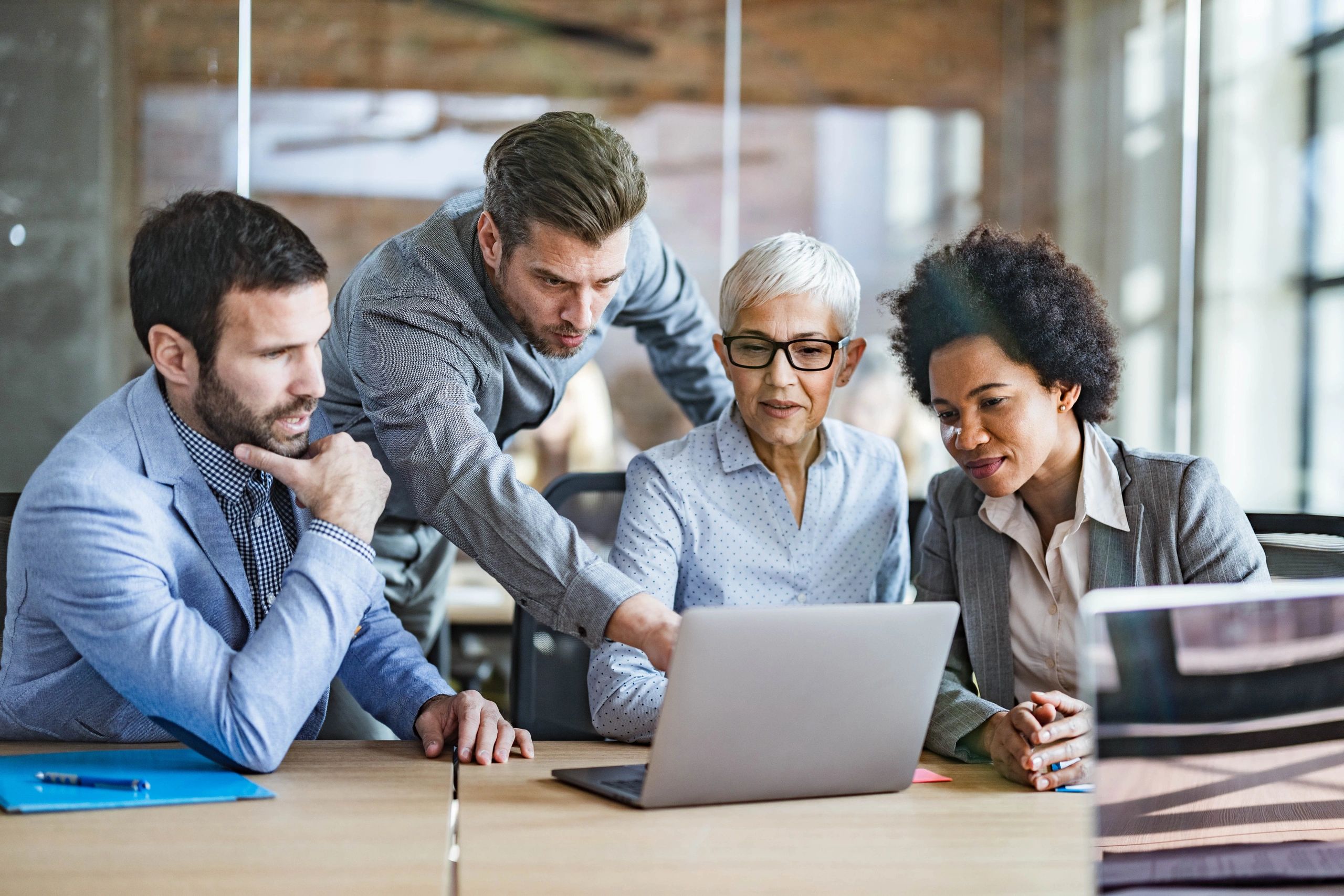 Team reviewing technical information on a laptop during an office meeting